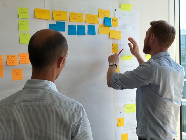 Two people working with post-it notes - small